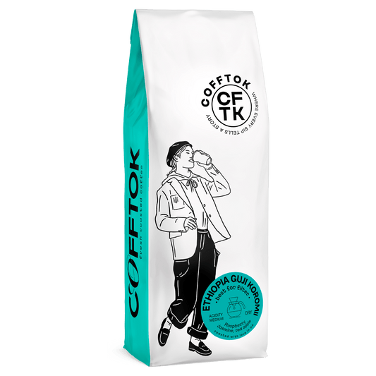 Ethiopia Guji Koromi specialty coffee beans in a white and teal bag with a modern design, featuring 100% Arabica with jasmine, red apple, and raspberry notes.